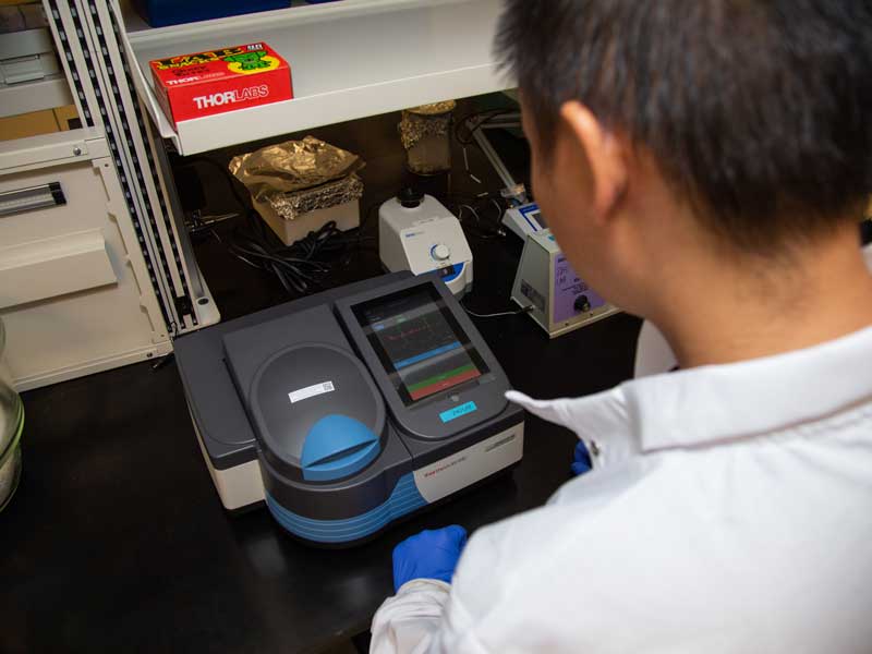 a researcher operating a piece of equipment in a lab