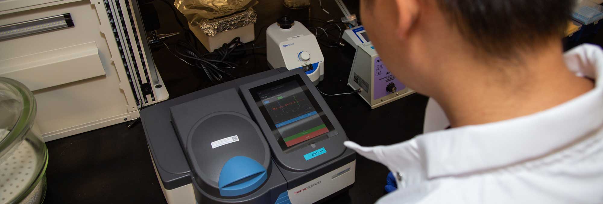 a researcher operating a piece of equipment in a lab