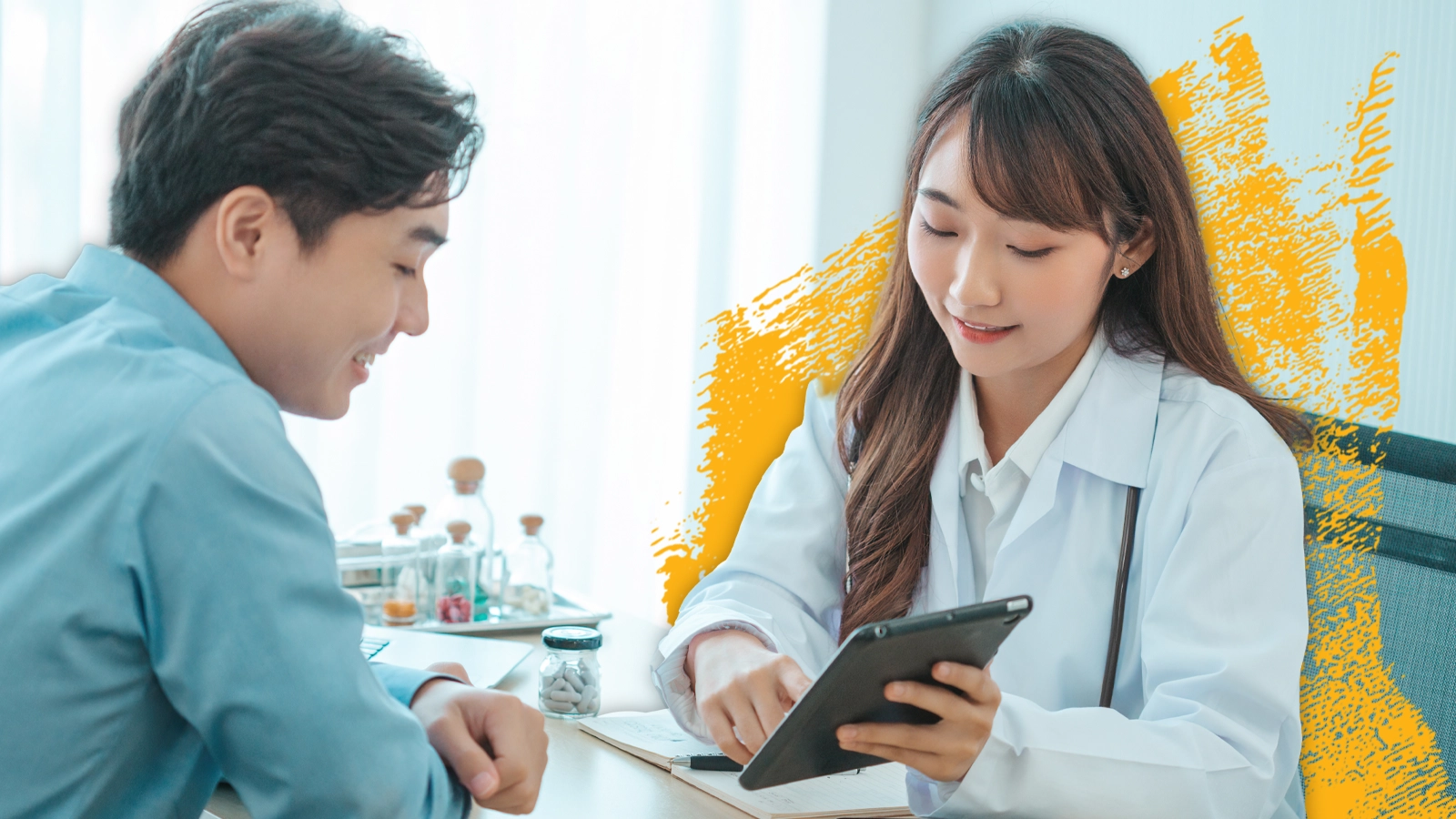 a health care worker in a clinic reviews information on a tablet computer along with a patient