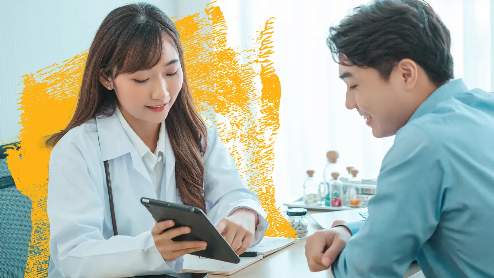 a health care worker in a clinic reviews information on a tablet computer along with a patient