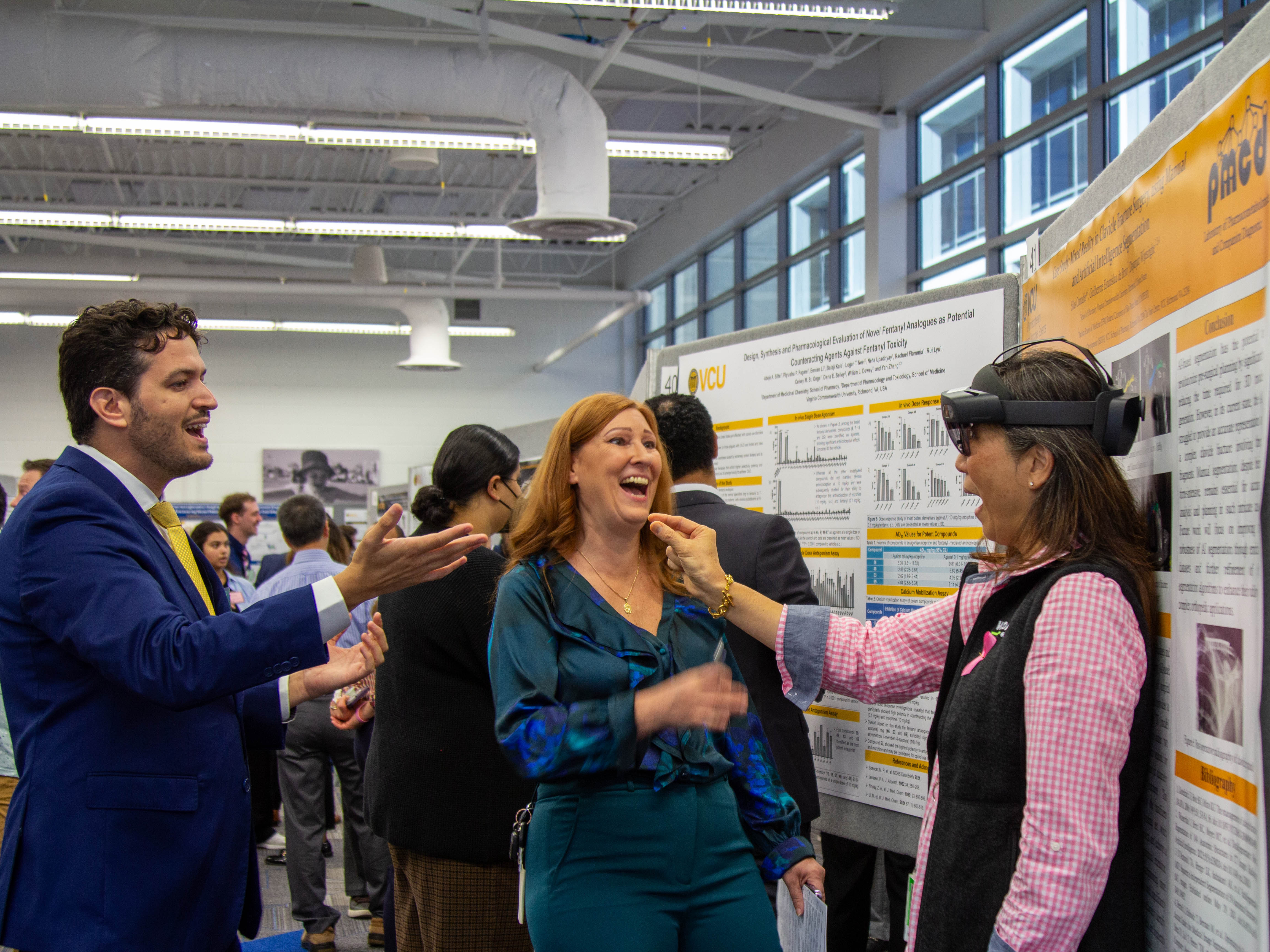 A Haleon employee standing in front of a poster presentation at Research Day uses a VR headset to simulate training done.