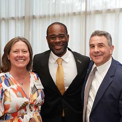 Dean Ogbonna standing with two V C U alumni.