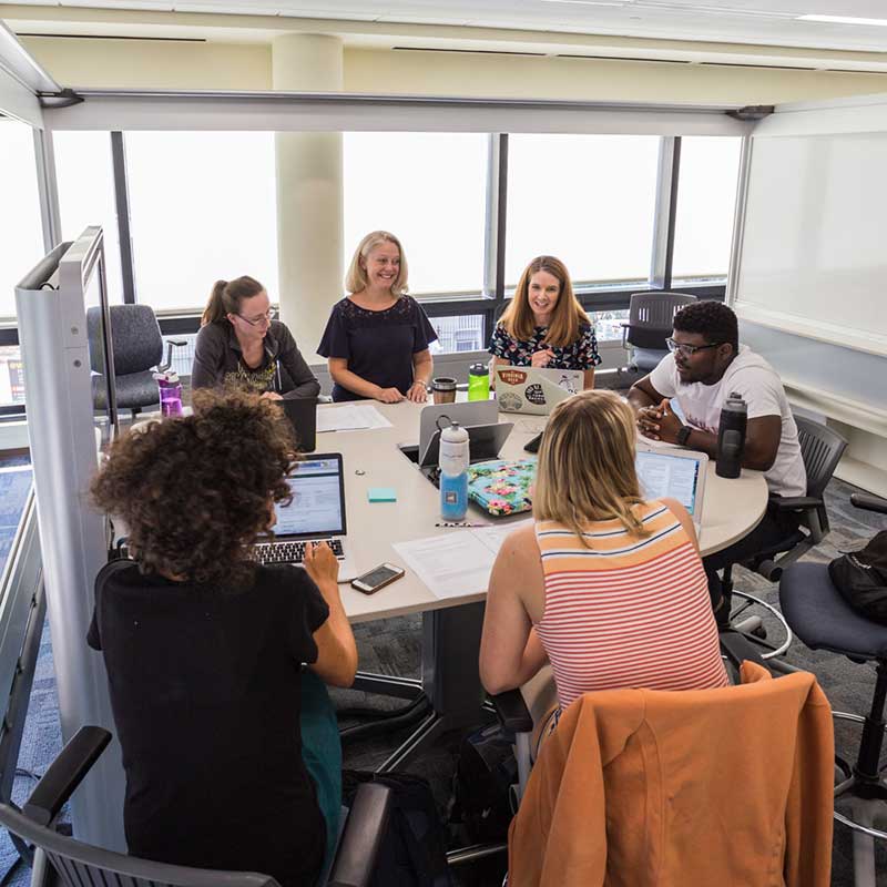 Third year pharmacy students in classroom around table.