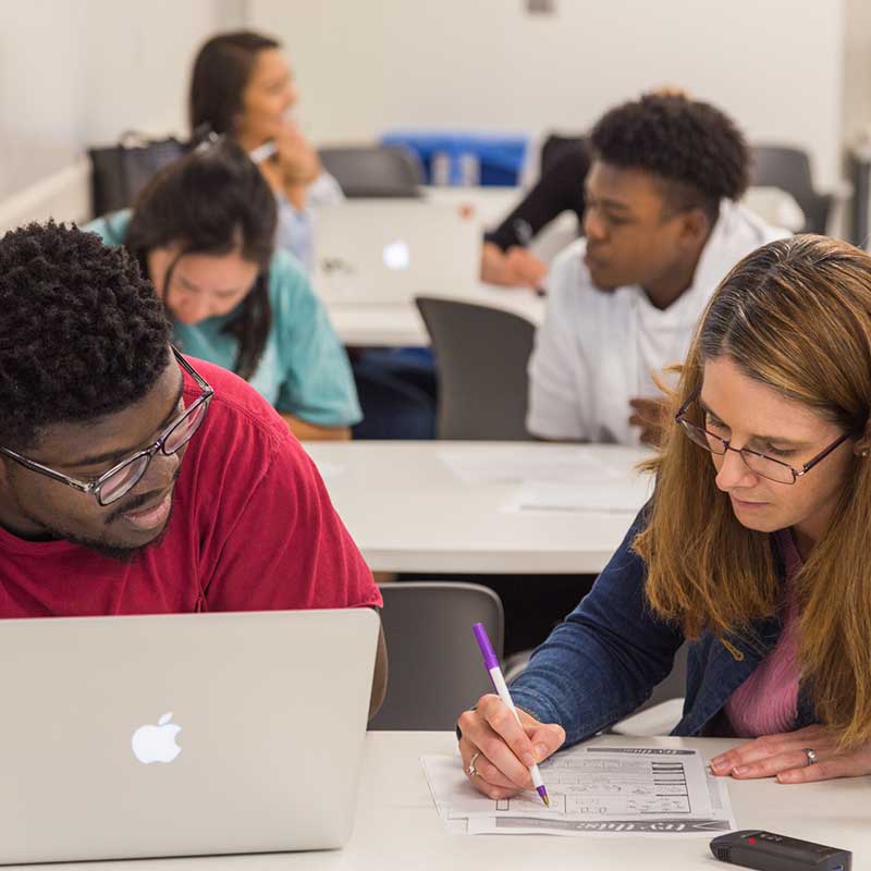 Faculty sitting with student teaching in classroom