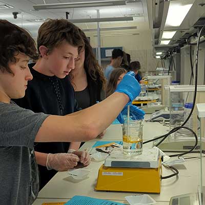 High school students using dropper in lab.