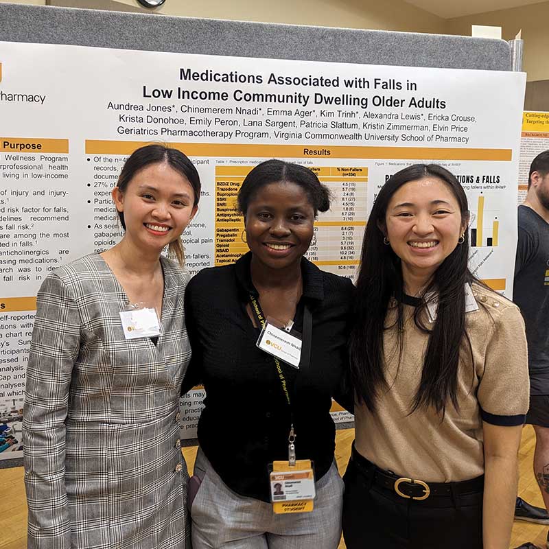 pharmacy students in front of research poster.