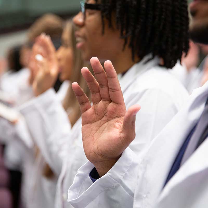 right hand raised taking oath.