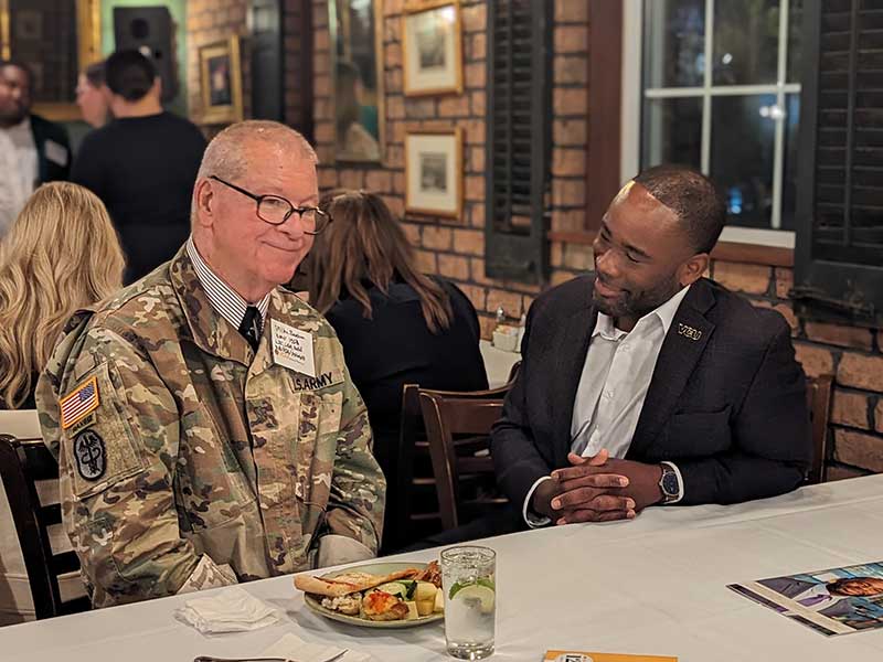 Dean K.C. Ogbonna sitting next to veteran.