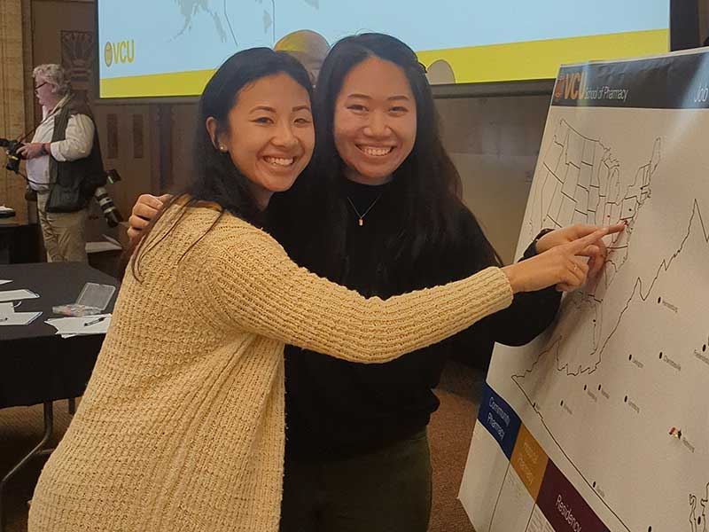 Two students point to a map.