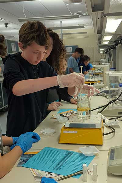 A high school student uses a lab equipment.