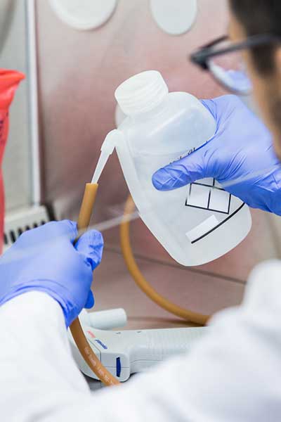 A researcher pours a liquid through a tube.