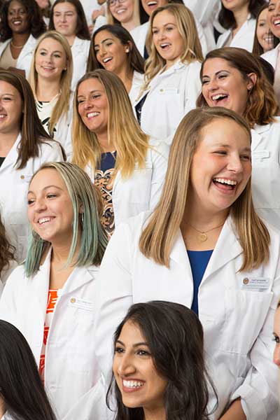 V C U pharmacy students wearing white coats laughing